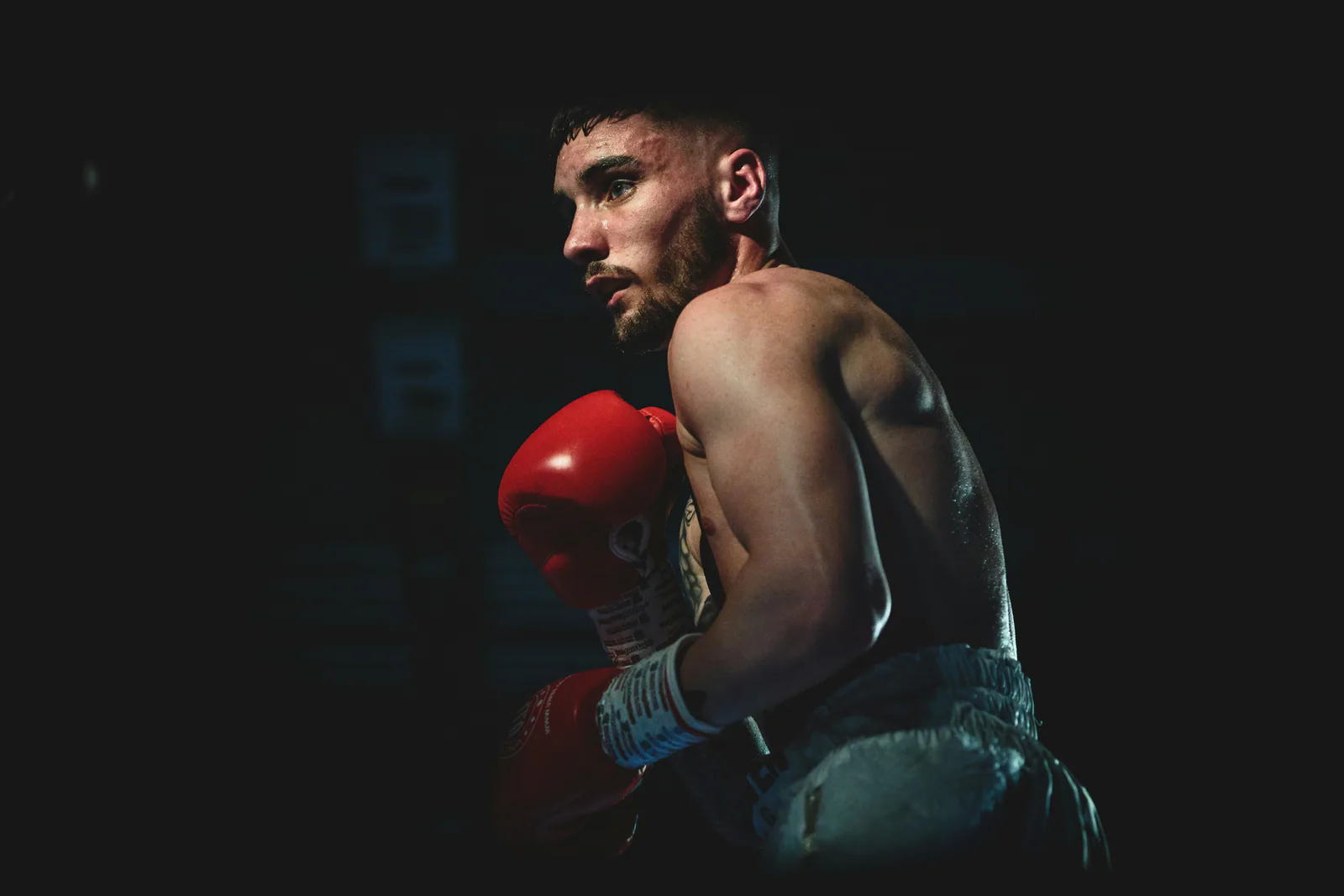 A fighter between rounds under dramatic light.